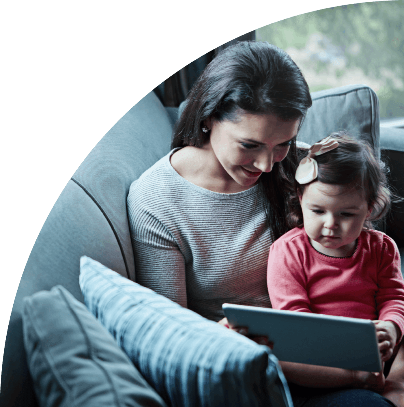 Mãe e bebê olhando um tablet em um ambiente confortável